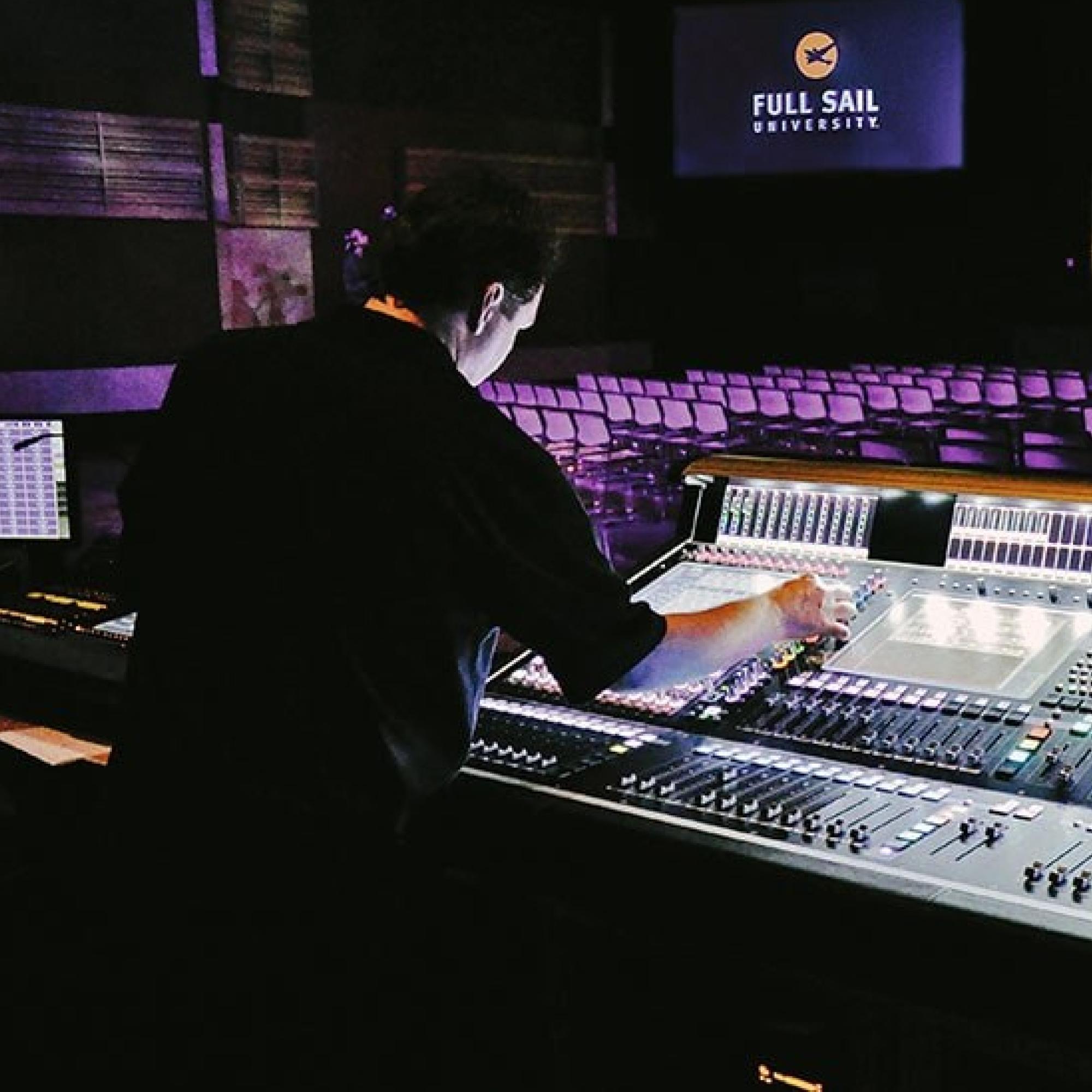 In the Full Sail Live Venue, a student works the production controls.